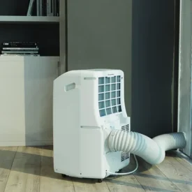 Klimatyzator przenośny Whirlpool PACF212CO W ustawiony w salonie. Materiały producenta Whirlpool.